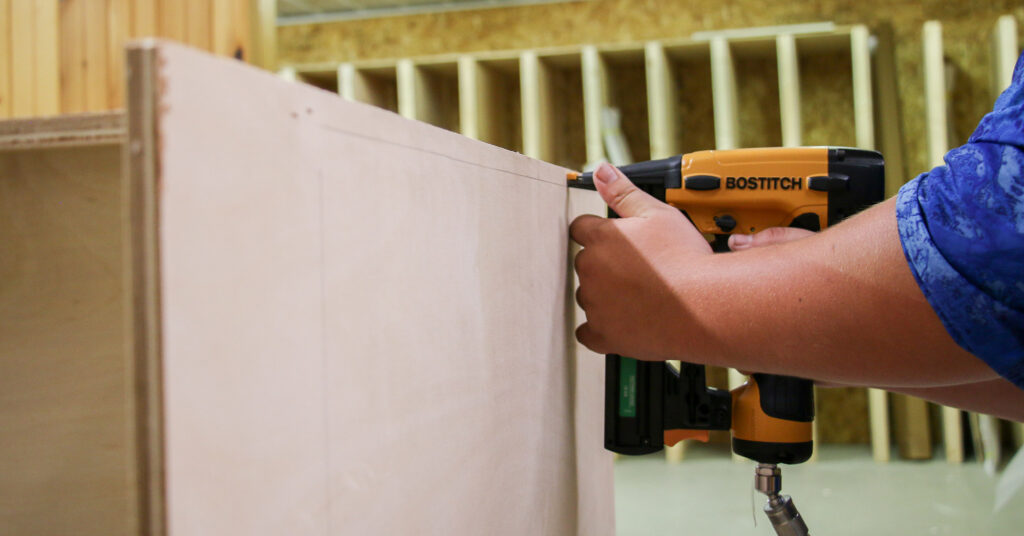 person drilling cabinet assembly together