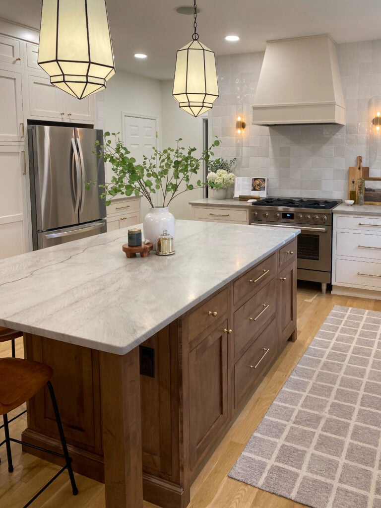 Dark stained kitchen island with wood range hood and inset drawer cabinets